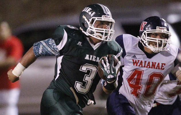 Aiea quarterback Mana Kaahanui took off running as Waianae's Justice Gomes pursued on Saturday, Aug. 24. (Jamm Aquino / Star-Advertiser)