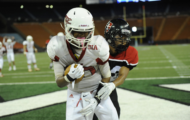 Kalani receiver Brandon Roberts wrapped up a pass in the end zone with 'Iolani defender Kevin Matsuoka hanging on in second-quarter action on Saturday, Aug. 10, 2013 at Aloha Stadium. (Bruce Asato / Star-Advertiser)