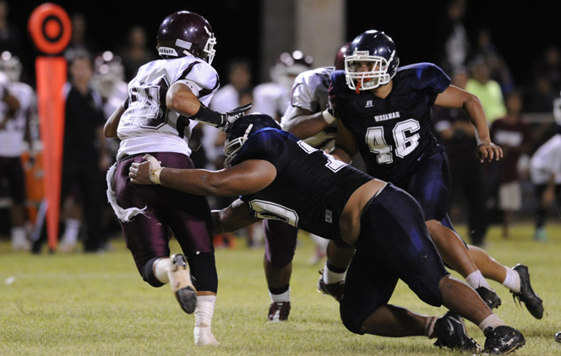 Waianae defender Senio Samisoni dropped Farrington quarterback Montana Liana in the second quarter of Friday night's game. (Bruce Asato / Star-Advertiser)