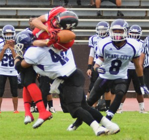Pearl City's Zebadiah Selu knocked the ball out of Cameron Henry's hands last week. RON KOSEN / SPECIAL TO THE STAR-ADVERTISER