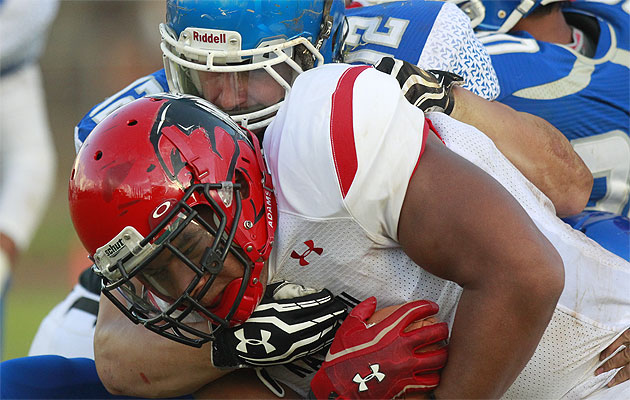 Kahuku offensive lineman Ra Elkington carried the ball as Moanalua's Kyle Bender held him back during a scrimmage on Thursday. Photo by Cindy Ellen Russell.
