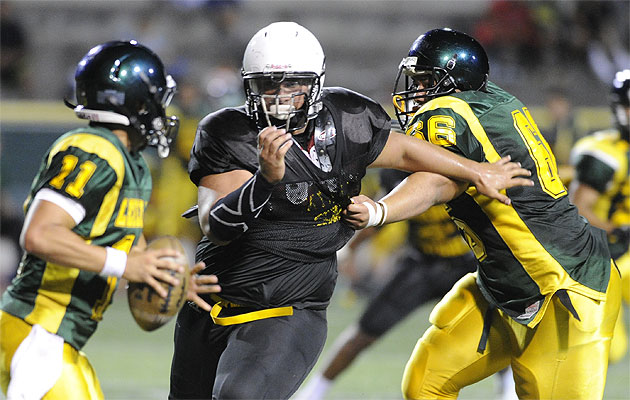 Mililani's  defensive lineman Rex Manu pressures and eventually sacks Leilehua's quarterback Kalaimoku Pauole on Thursday. HSA photo by Bruce Asato