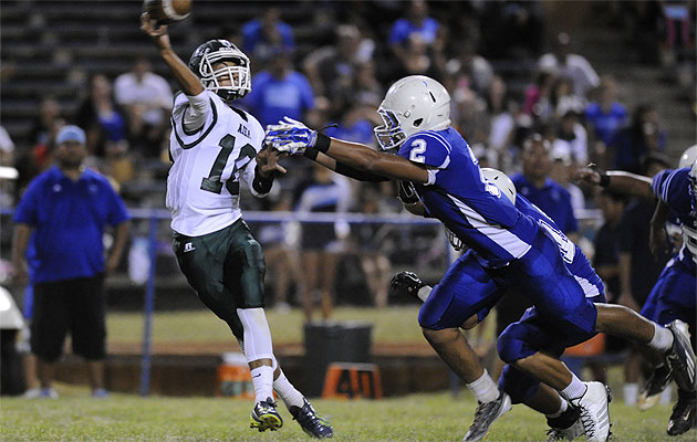 Aiea's Kobe Kato gets rid of the football under pressure by Kailua's Peter Albinio on Saturday. HSA photo by Bruce Asato