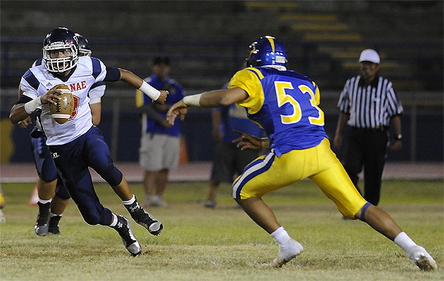 Waianae quarterback Ioane Kaluhiokalani Jr. scrambles as Kaiser's Levi Richards closes on the play. HSA photo by Bruce Asato