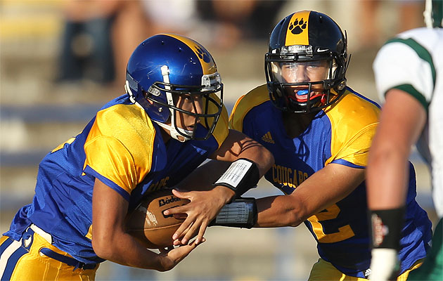Kaiser quarterback Kalawai'a Judd handed off to Justin Ikei in the Cougars' rout of Na Alii on Friday night. Darryl Oumi / Special to the Star-Advertiser.
