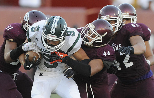 Aiea's Kodi Ongory-Mathias is stopped by Farrington's Asalemo Sila,  Joey Maae and Bryce Tatupu-Leopoldo in a game this season. HSA photo by Bruce Asato.