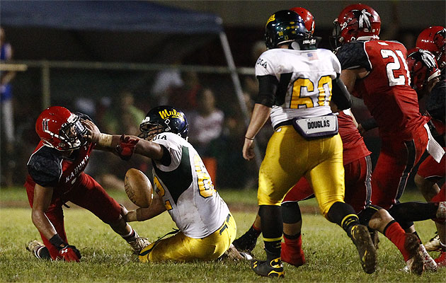 Kahuku's Alohi Gilman and Leilehua's Our Savior Smith battled for a loose ball on Saturday. The Red Raiders have relied on their defense and special teams until their offense comes along. (Honolulu Star-Advertiser/Jamm Aquino)