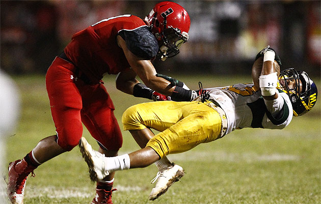 Kahuku's Keala Santiago throws Leilehua's Jadan Gilliland to the ground on Friday. (Honolulu Star-Advertiser/Jamm Aquino)