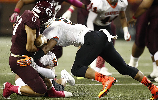 Campbell's Abiel Saito and Unity Kea Cambra forced Farrington running back Challen Faamatau to cough up the ball in a 2014 game. Jamm Aquino/Star-Advertiser.