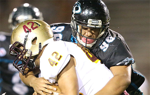 Castle's Ryan Mohika was stopped by Kapolei's Johnny Morrison on Friday. Jay Metzger / Special to the Star-Advertiser.