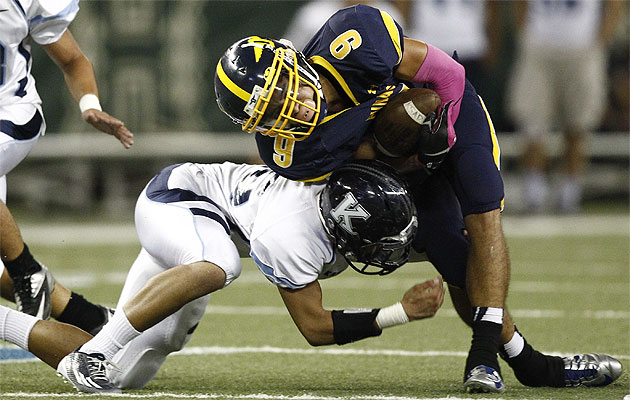 Punahou's Kanawai Noa was hit by Kamehameha's Mason Chow on Friday. Jamm Aquino / Star-Advertiser.