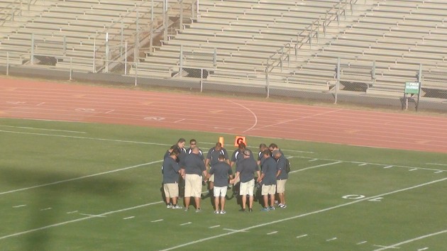 Kamehameha-Hawaii coaches in prayer before the game.