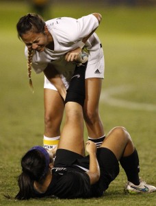 Mililani's Robyn Peiler helped ‘Iolani's Kristen Hori stretch during the second overtime period of the Division I girls soccer state championship game on Feb.21 at Waipio Peninsula Soccer Stadium.  (Jamm Aquino/Honolulu Star-Advertiser).