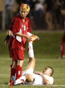 Kalani's Ryan Abe came to the aid of ‘Iolani's Spencer Ho in the second overtime period in the semifinals of the Division I boys soccer state championships on Feb. 27 at Waipio Peninsula Soccer Stadium.  (Jamm Aquino/Honolulu Star-Advertiser).