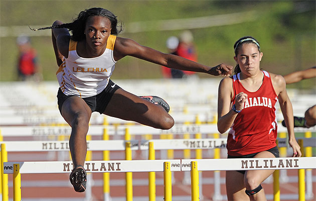 Ky'Yonna Chapman of Leilehua HS clears the last hurdle for the win in the Girls 100 meter hurdles event in the OIA Track and Field Championships at Mililani. At right is Emma Knott of Waialua HS. HSA photo by Bruce Asato