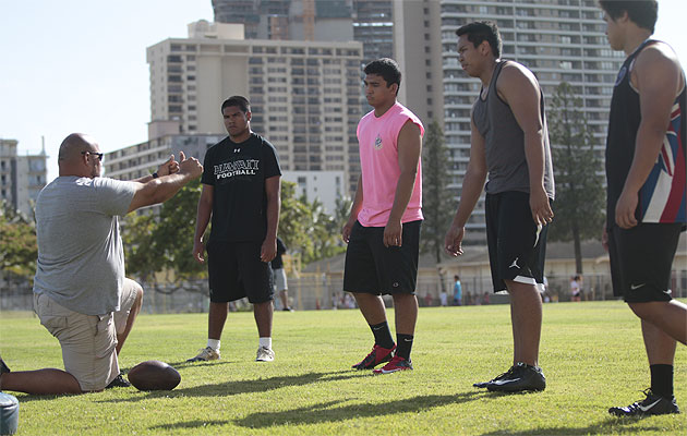 ‘Iolani coach Kevin Manuel instructs players on the defensive line during a May 19 practice. / Krystle Marcellus / Star-Advertiser.