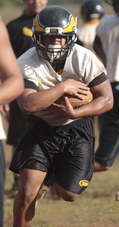 Sunshine Anuenue carried the ball on a running play during spring drills Tuesday. Krystle Marcellus / Star-Advertiser.