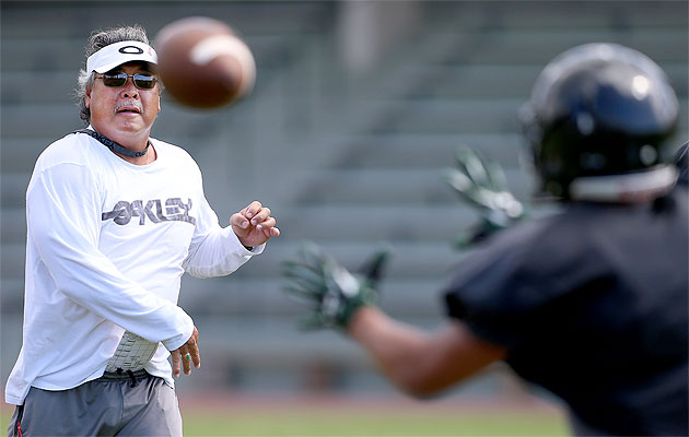 ‘Iolani football coach Wendell Look threw a pass to one of his players during Monday's practice on campus. Jay Metzger / Special to the Star-Advertiser.