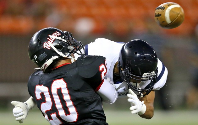 Kamehameha-Maui's Kampala Kaniaupio made a hit on ‘Iolani's Tamatane Aga, left, to break up a pass on Saturday in the Father Bray Classic. The Raiders beat the visiting Warriors 48-14 in one of eight weekend games involving teams from the Neighbor Islands. Jay Metzger / Honolulu Star-Advertiser.