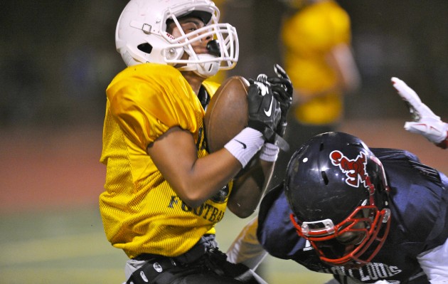 Mililani receiver Noah Domogsac made a touchdown catch in an Aug. 8 scrimmage against Saint Louis. The Trojans are No. 6 in the MaxPreps national rankings, and the Crusaders are No. 28. Bruce Asato / Honolulu Star-Advertiser.