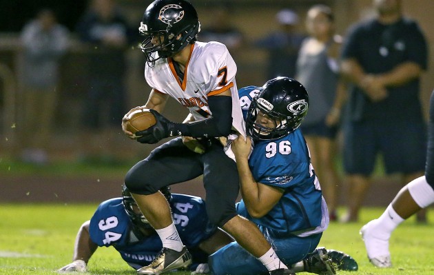 Kapolei's Aizak Naulu (94) and Johnny Morrison (96) teamed up to bring down Campbell quarterback Kawika Ulufale during Friday  night's game. The Hurricanes rallied back from a 7-3 deficit to defeat the Sabers 16-7. Jay Metzger / Honolulu Star-Advertiser.
