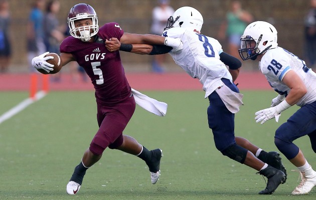 Farrington's Kingston Moses-Sanchez (5) tries to get loose against Kailua's Kalei Kealoha-Machado (8) and Joseph Byers (28) during the second quarter of the game on Saturday at Roosevelt High School. Jay Metzger/Special to Star-Advertiser