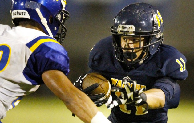 Andrew Simanu put the stiff arm on Kaiser Cougar Andrew Kaufusi in a game on Friday night. George Lee / Honolulu Star-Advertiser