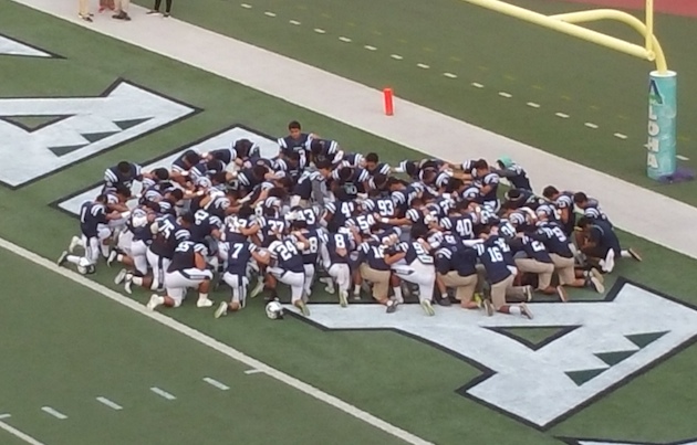 Kamehameha huddles in the end zone before the game. 