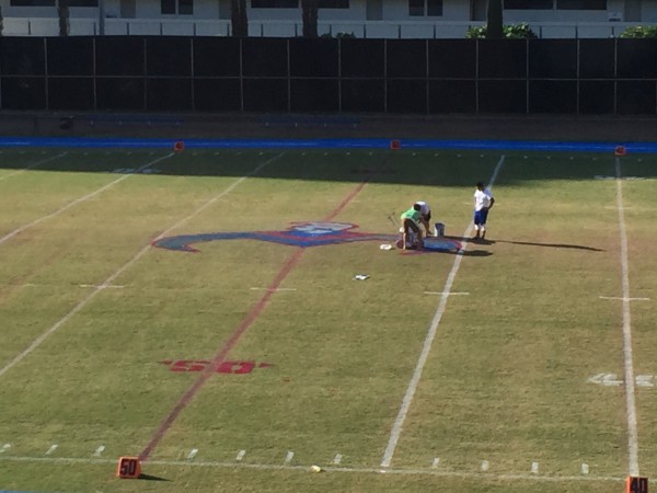 Coach Jason Cauley and some of his staff applied pink paint to the field at Moanalua for Breast Cancer Awareness Month. 