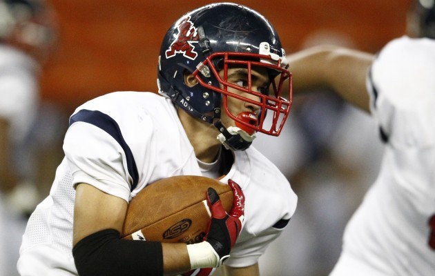 Saint Louis' Dylan Silva hit the hole during a rushing attempt in Thursday night's 51-36 victory over Kamehameha at Aloha Stadium. Both teams are trying to win the Interscholastic League of Honolulu's second round in order to get a spot in a playoff game against first-round champion Punahou. Jamm Aquino / Honolulu Star-Advertiser.