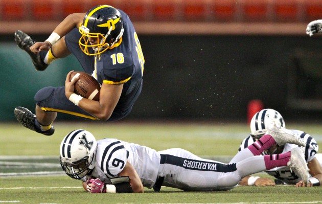 Punahou QB Ephraim Tuliloa is upended by Kamehameha DB Kainalu Martin. Tuliloa passed for a school-record 442 yards in a 26-23 comeback victory. Jamm Aquino/Star-Advertiser