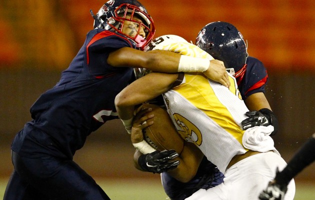 Saint Louis' Kainalu Paikai, left, was in on this tackle of Mililani's Vavae Malepeai during Friday night's Division I football state semifinal at Aloha Stadium. The Crusaders won 56-30 and will play Kahuku next Friday for the title. Jamm Aquino / Honolulu Star-Advertiser.