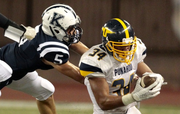 Kamehameha's Tainoa Foster brought down Punahou's Wayne Taulapapa in a game earlier this year. Photo by Jamm Aquino/Star-Advertiser.