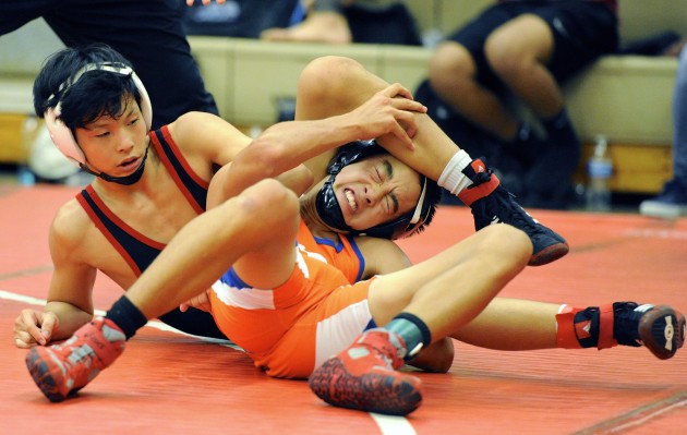 ‘Iolani's Kainoa Torigoe, left, defeated Kalaheo's Colby Otero in the 106-pound quarterfinals in the Hawaii Wrestling Officials Association Scholarship Tournament on Friday. Previously, Torigoe knocked off top-seeded Isaac Adriano of Campbell. Bruce Asato / Honolulu Star-Advertiser.