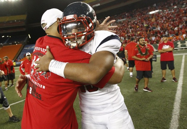 St. Louis QB Tua Tagovailoa and Kahuku coach Vavae Tata embraced after last year's state title game the Red Raiders won 39-14. Photo by Jamm Aquino/Star-Advertiser.