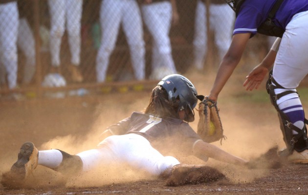Mililani's Brooke Yasuda avoided the tag by Pearl City's Hailey-Alexis Yamguchi and slid in safely for the winning run  in the Trojans' 2-1 victory over the Chargers on March 31. Jamm Aquino / Honolulu Star-Advertiser.