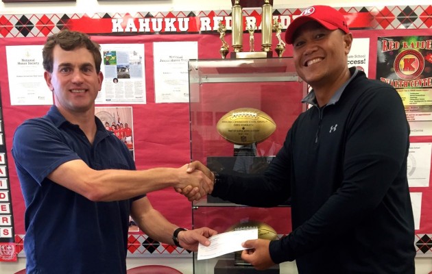 Kahuku football coach Vavae Tata accepted a check on the campus recently. Photo courtesy Continental Pacific.