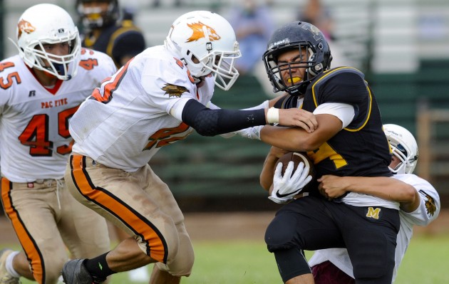 Pac-Five's Kamalei Goss stopped McKinley running back Joshua Leza during Saturday night's game. There were 12 games around the state in Week 1. Bruce Asato / Honolulu Star-Advertiser.