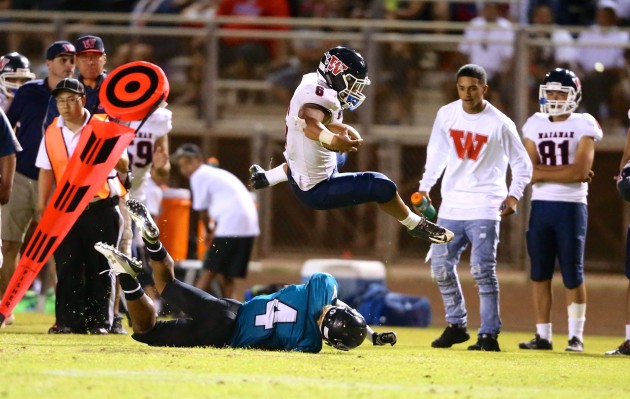 Waianae running back Rico Rosario leaped over a Kapolei defender for extra yards in a 35-14 win on Saturday night. Photo by Jay Metzger/Special to the Star-Advertiser.