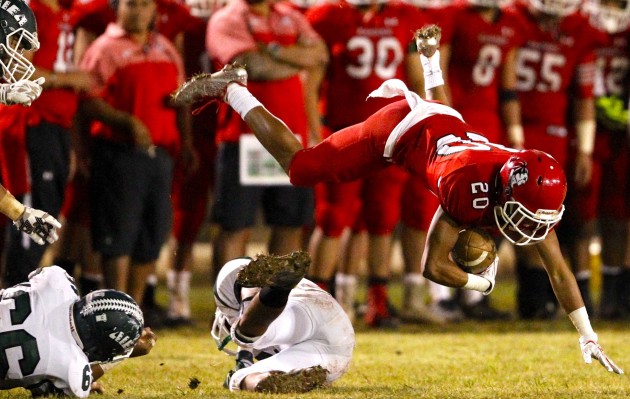 Kahuku's Stokes Nihipali-Botelho had two interceptions and a kickoff return for a touchdown in a 44-0 win over Campbell on Friday night. In photo, Nihipali-Botelho dove over an Aiea defender. Jamm Aquino / Honolulu Star-Advertiser.