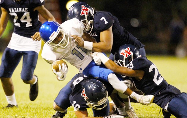 Waianae's Sireadan Sana, Francis Mailo and Dalton Rajkowski brought down Moanalua's Rylan Miguel. Photo by George F. Lee/Star-Advertiser.