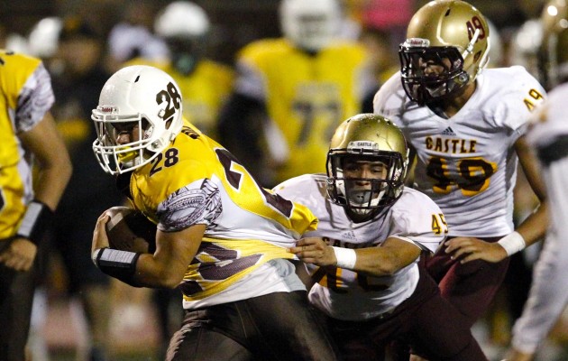 Mililani running back Kailiohu Kila got  past Castle defensive back Paul Tyquiengco during the Trojans' 42-0 win Friday night. Jamm Aquino / Honolulu Star-Advertiser.