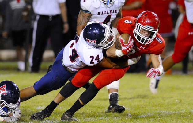 Kahuku's Harmon Brown rushed for some of his 90 yards on this play in which he was tackled by Waianae's Elijah Brame. Bruce Asato / Honolulu Star-Advertiser. Aug. 26, 2016