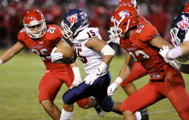 Kahuku's Kesi Ah-Hoy (26) and Codie Sauvao converged on Waianae running back Rico Rosario in a 28-0 Kahuku win earlier this year. Photo by Bruce Asato/Star-Advertiser.