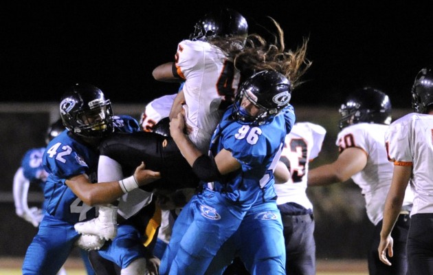 Kapolei's Destyn White and Treven Maae doubled up to take down a Campbell running back on opening weekend. Photo by Bruce Asato/Star-Advertiser.