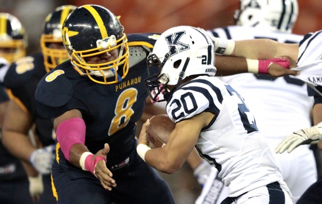 Kamehameha's Kanoa Shannon is about to be tackled by Punahou's Miki Suguturaga in a game in October 2015. Jamm Aquino /Star-Advertiser