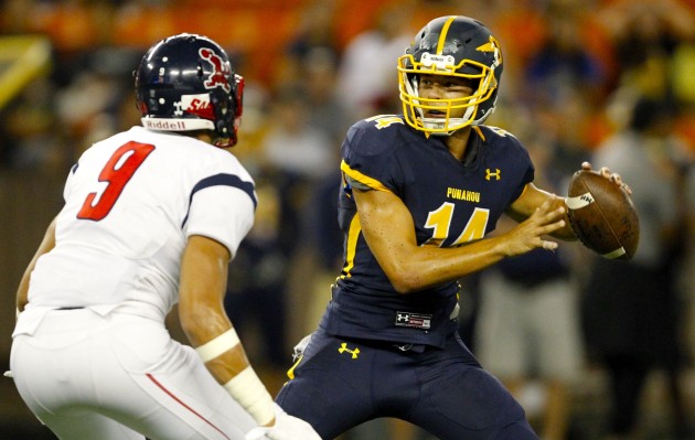 2016 September 9 SPT - HSA Photo by Jamm Aquino. Punahou quarterback Nick Kapule (14) looks to pass while under pressure from Saint Louis linebacker Isaiah Feary (9) during the first half of an ILH football game between the Punahou Buffanblu and the Saint Louis Crusaders on Friday, September 9, 2016 at Aloha Stadium in Halawa.