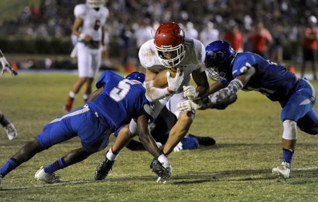 Kahuku's Harmon Brown fought for yardage against Moanalua in a game last month. Photo by Bruce Asato/Star-Advertiser.