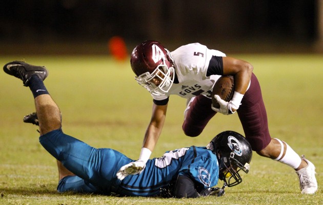 Kapolei's Adam Berg made a hard open-field tackle of Farrington's Kingston Moses-Sanchez on Friday night. Moses-Sanchez received medical attention after the play and eventually limped to the sideline. Kapolei clinched the Oahu Interscholastic Association Red regular-season title with a 28-7 victory. Jamm Aquino / Honolulu Star-Advertiser.