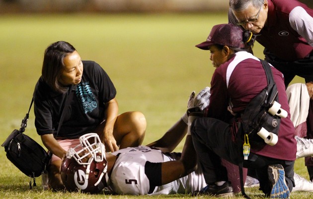 Farrington trainers helped receiver Kingston Moses-Sanchez after he was injured in a game against Kapolei last year. Photo by Jamm Aquino/Star-Advertiser.